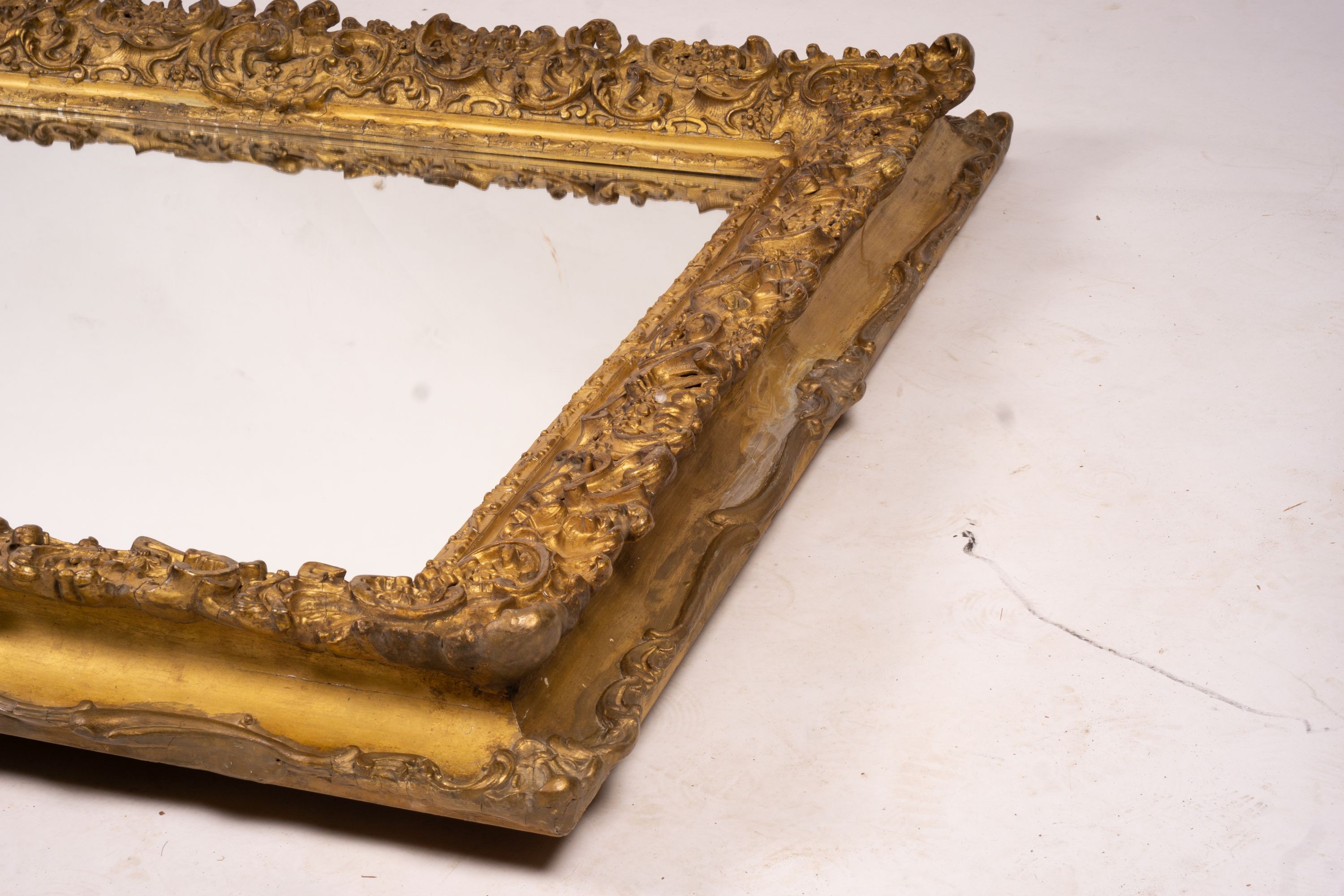 An ornate Victorian giltwood and gesso rectangular wall mirror (formerly a picture frame) width 130cm, height 112cm